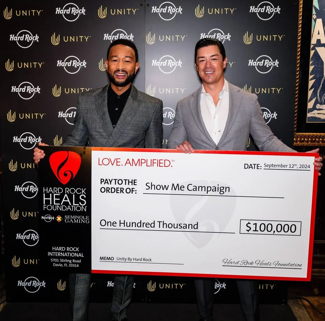 Keith Sheldon presents donation check to John Legend on behalf of Hard Rock Heals Foundation